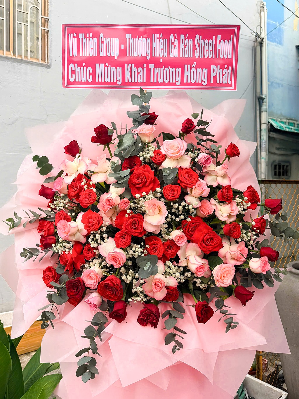 Bó hoa khai trương nổi bật bên biển hiệu